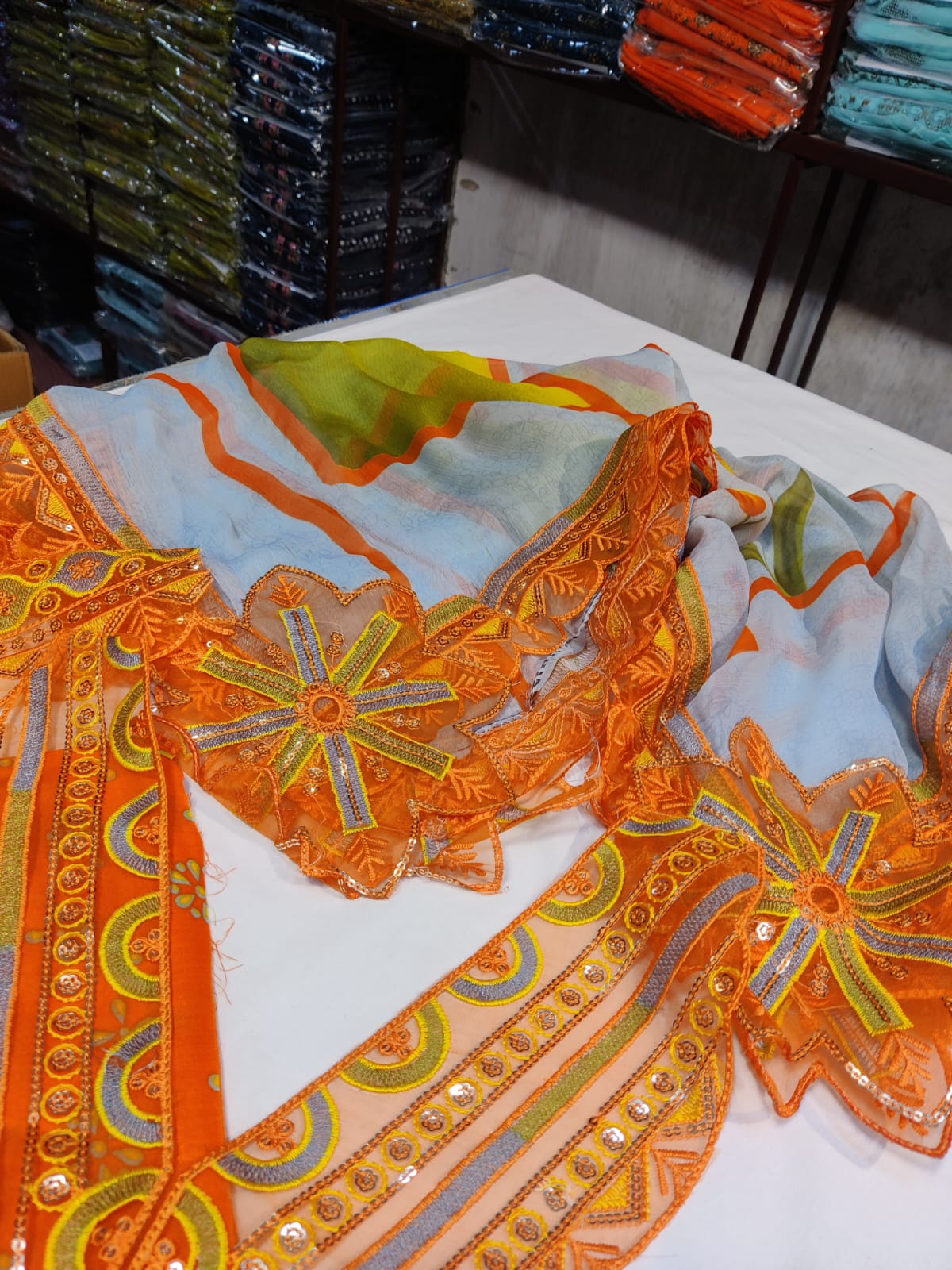 Danish Cloth Nureh orange textile with vibrant orange fabric and intricate pattern, close-up view of the woven material